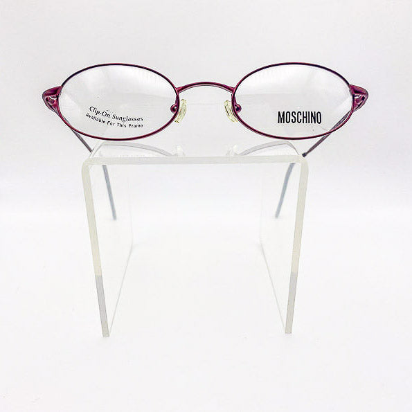 Moschino eyeglasses on a clear stand with a white background
