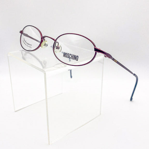 Metal oval eyeglasses with 'Moschino' branding on a white background