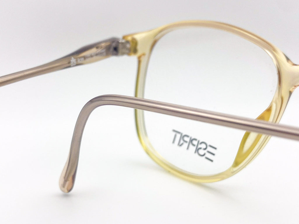 Vintage yellow eyeglasses with 'Esprit' branding on a white background