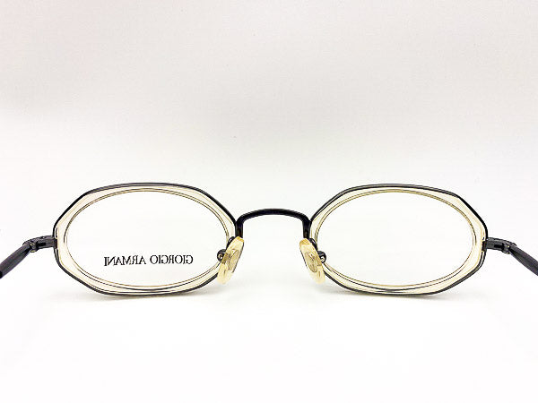 Eyeglasses with clear grey metal frame and branding on a white background