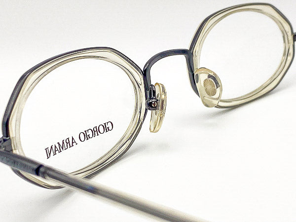 Close-up of a pair of eyeglasses with 'Giorgio Armani' branding on a white background