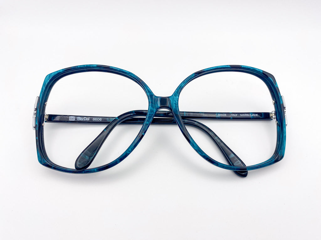 Vintage black and turquoise eyeglasses on a white background