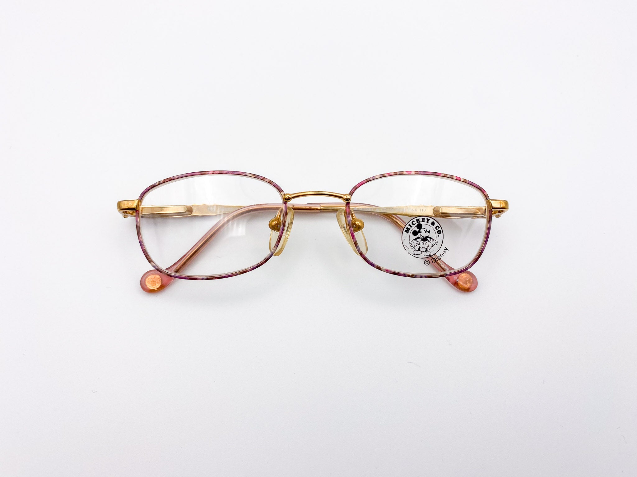 Gold-framed kids eyeglasses with red accents on a white background