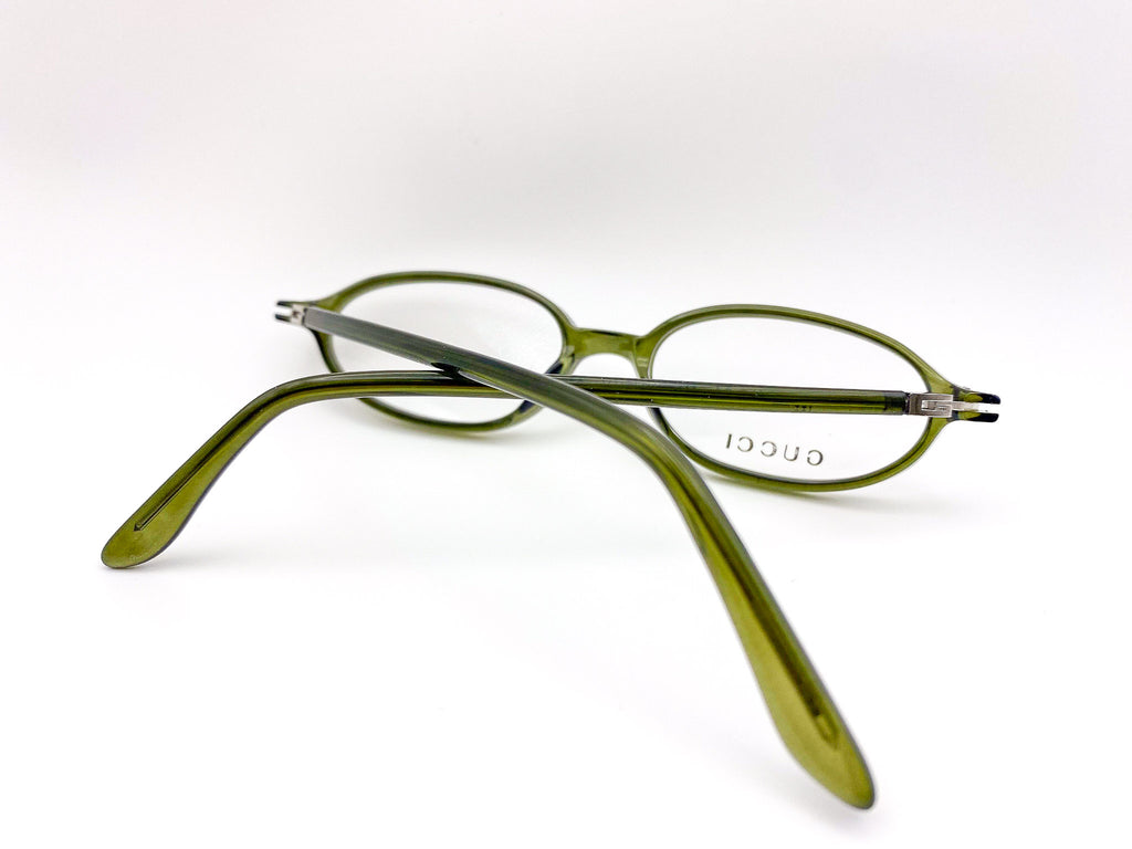 Vintage green Gucci eyeglasses on a white background