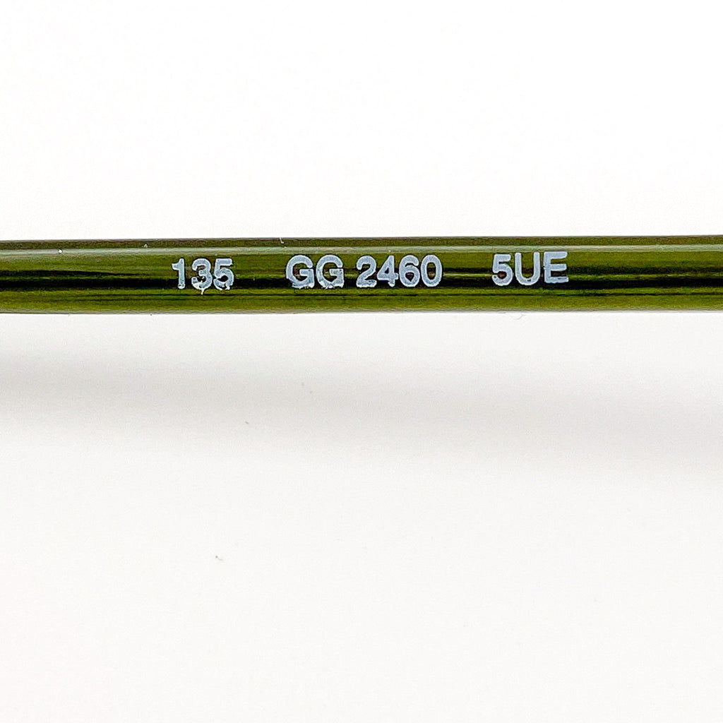 Close-up of a green eyeglasses with engraved text on a white background