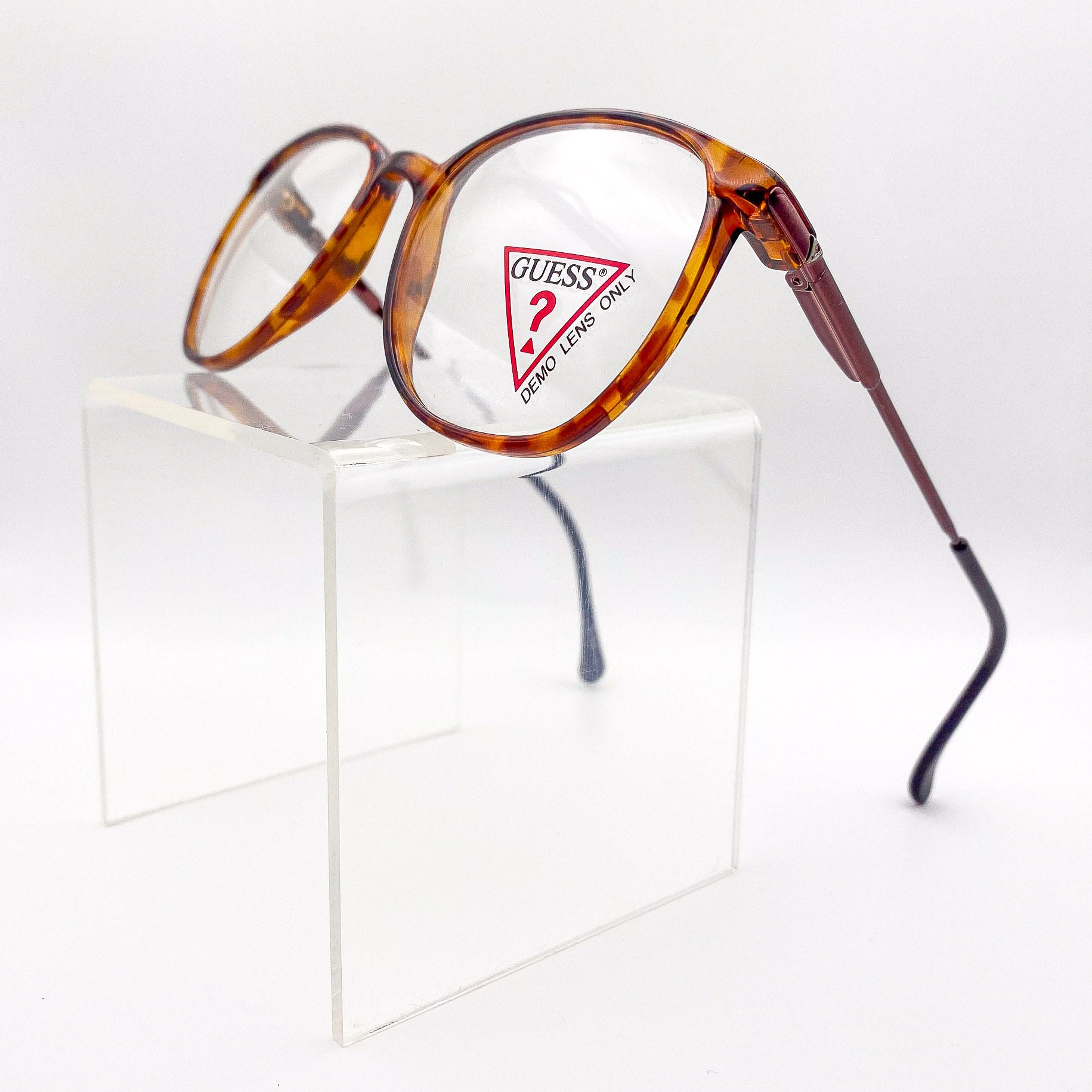 Tortoiseshell eyeglasses with Guess logo on a white background