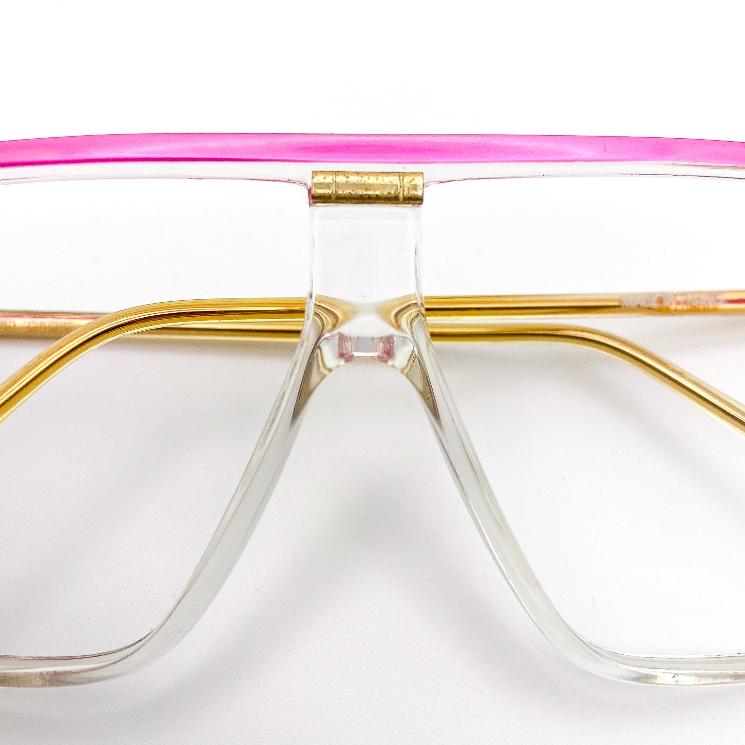 Vintage eyeglasses with a pink and gold frame on a white background