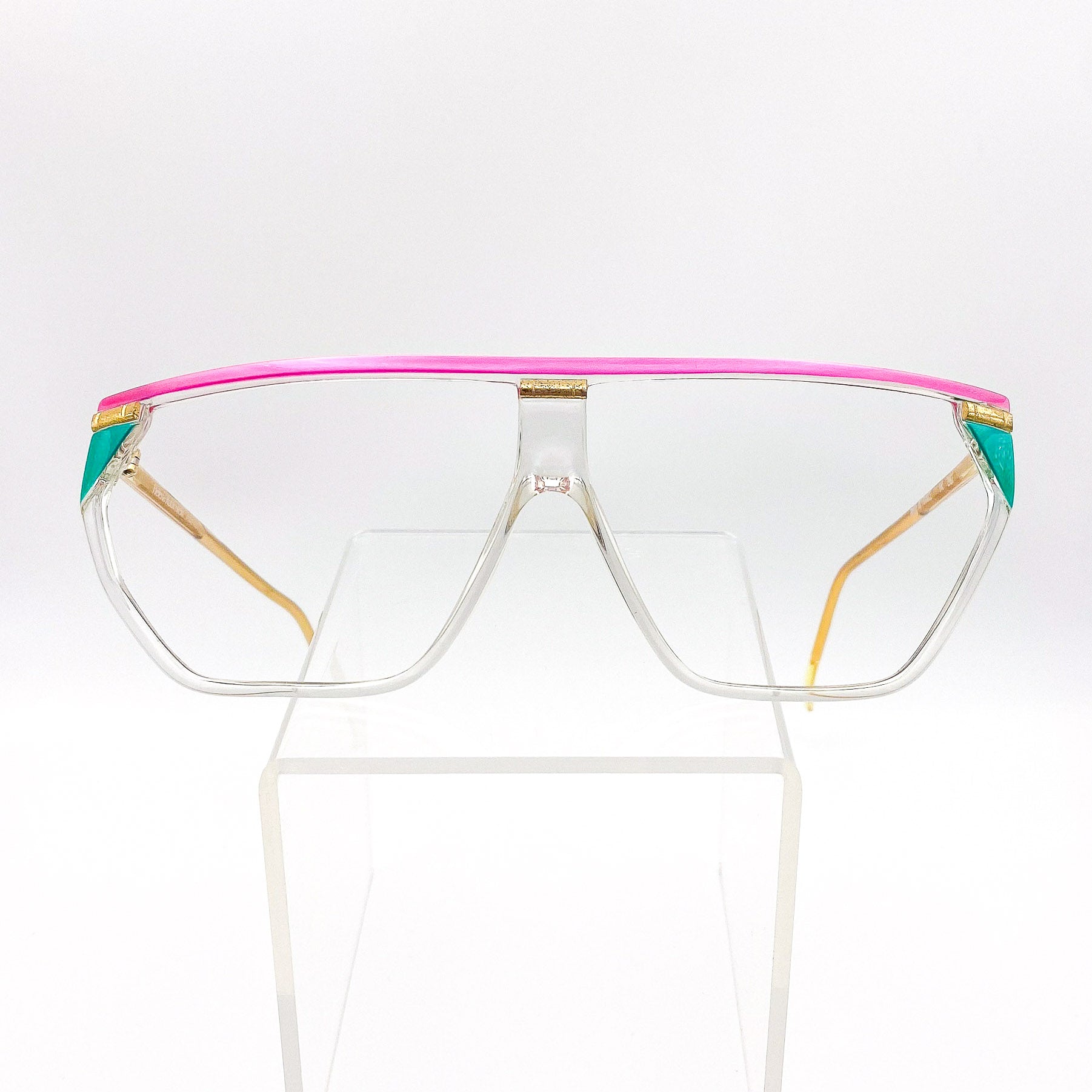 Clear glasses with a pink and green frame on a white background