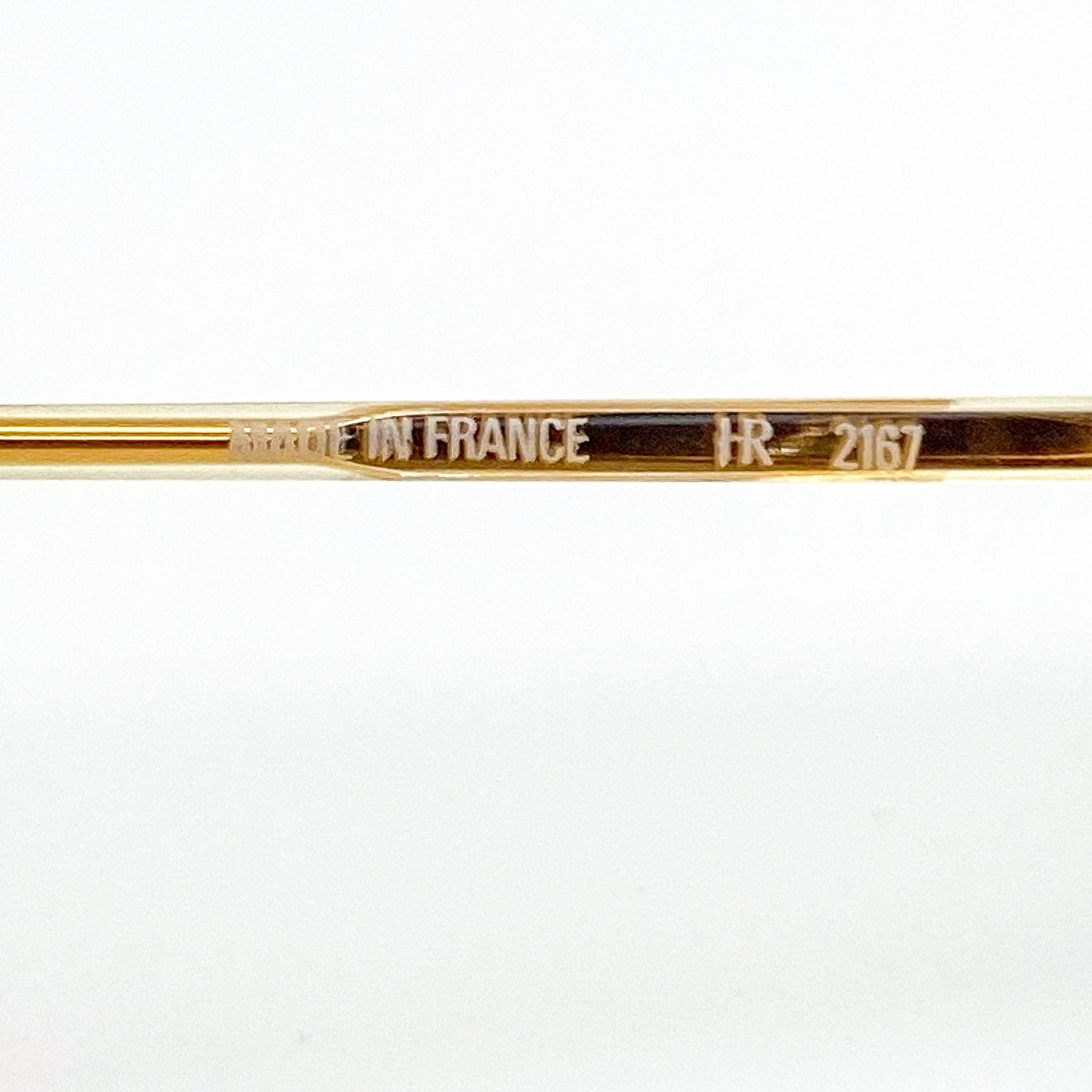 Gold-colored temple stem with 'MADE IN FRANCE' and 'FR-2167' text on a white background