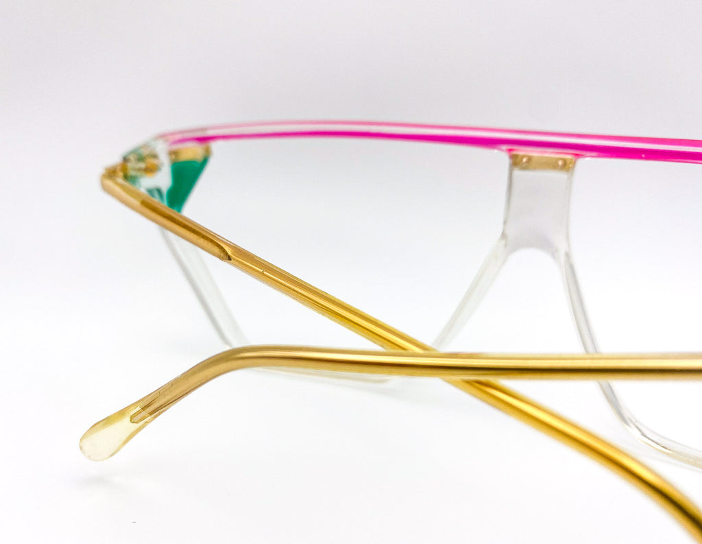 Eyeglasses with gold frame and pink interior on a white background