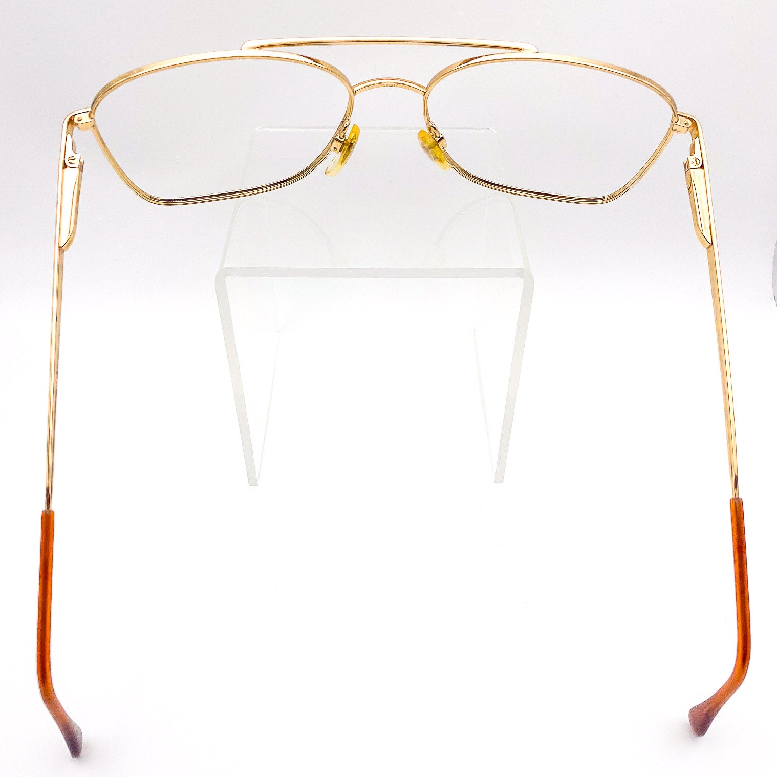 Gold-framed eyeglasses with brow bar on a white background