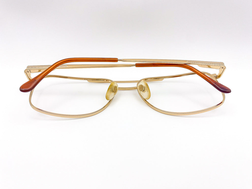 Gold-framed aviator eyeglasses with brown accents on a white background