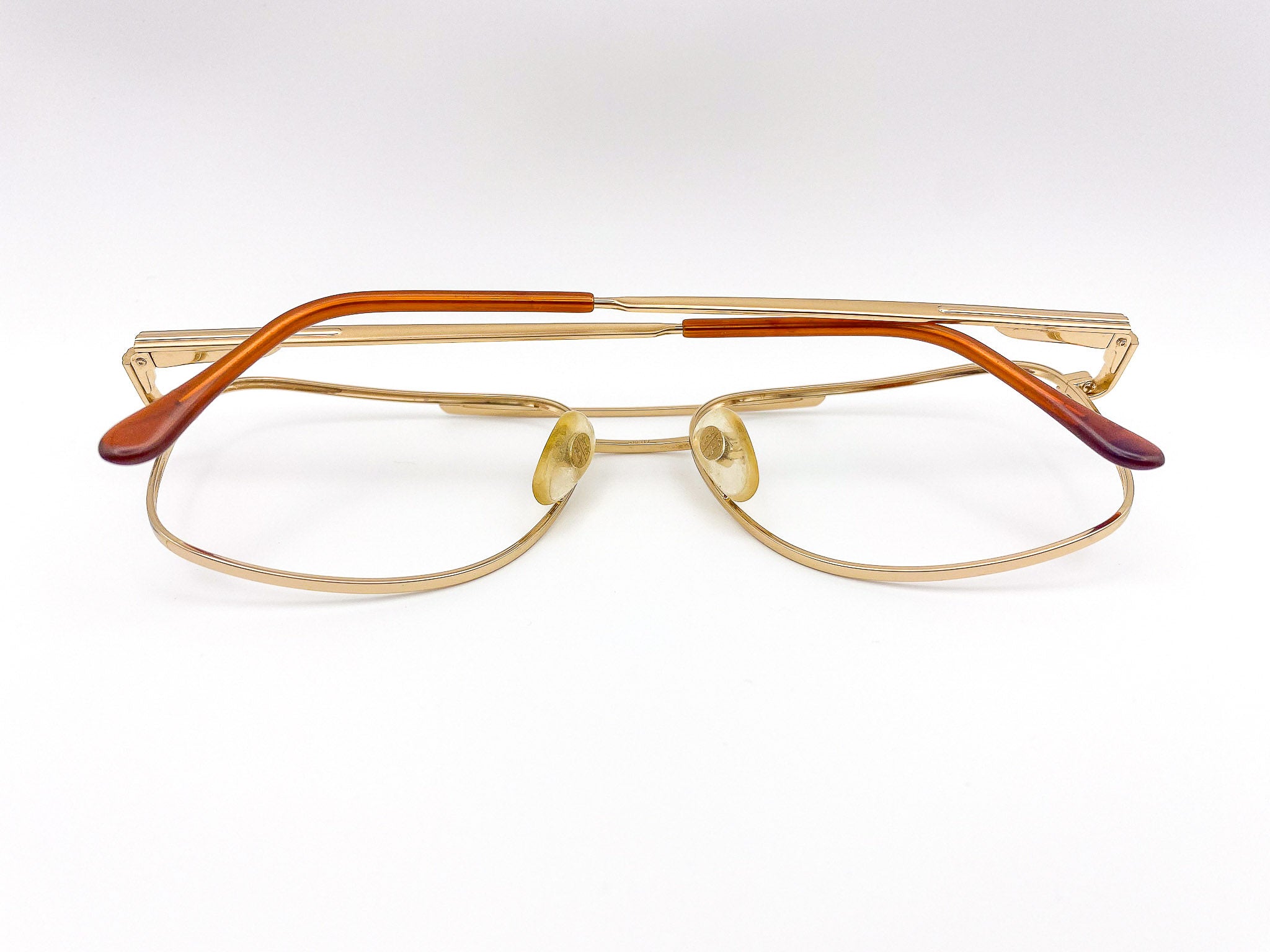 Gold-framed aviator eyeglasses with brown accents on a white background