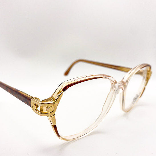 Clear eyeglasses with gold accents and tortoiseshell arms on a white background