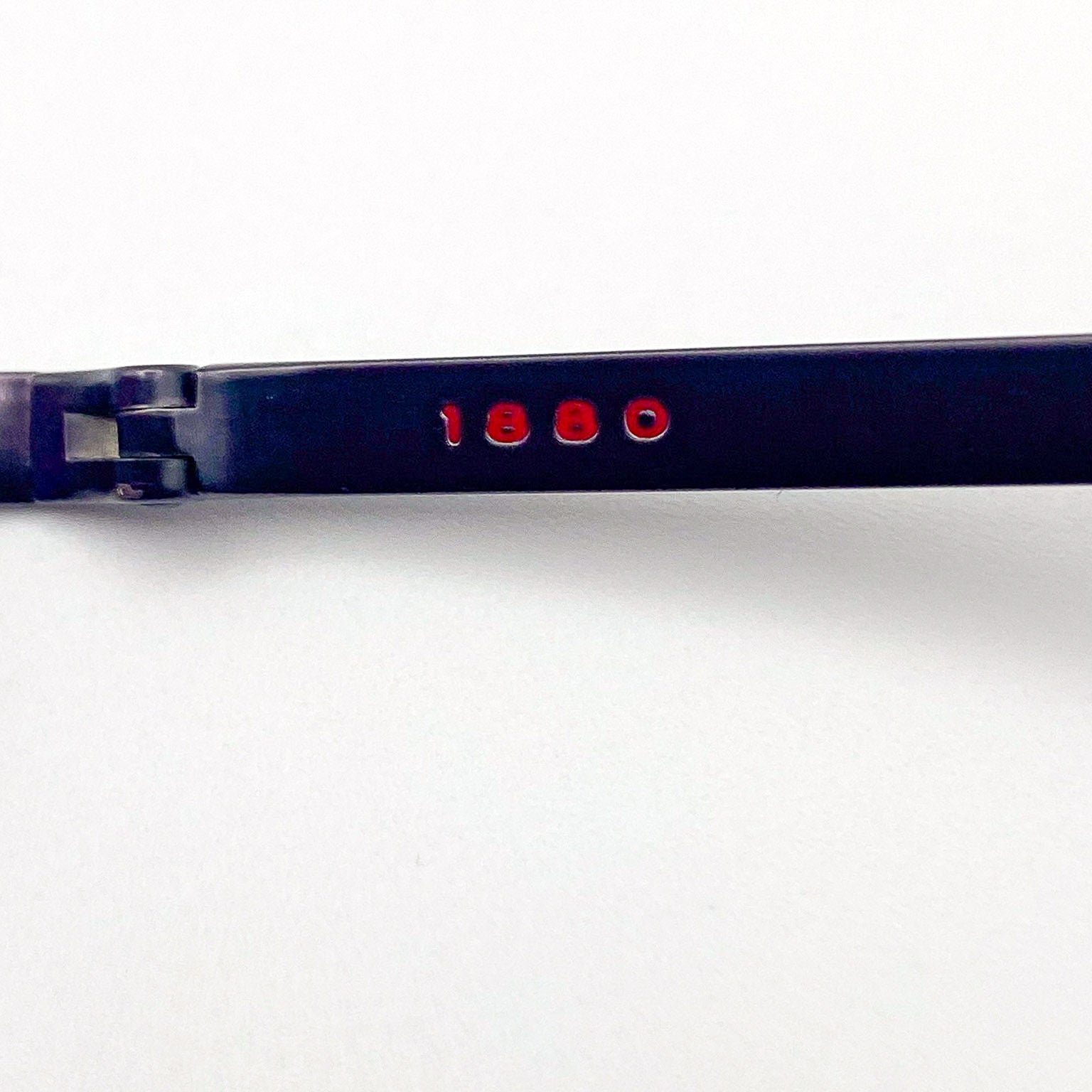 Close-up of an eyeglasses frame with '1880' on a white background