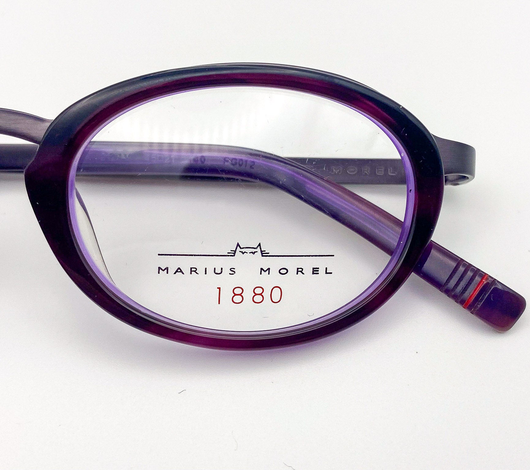 Purple eyeglasses with 'Marius Morel' branding on a white background