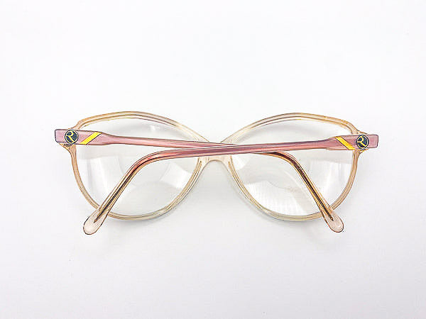 Oversized eyeglasses with a gold and pink frame on a white background