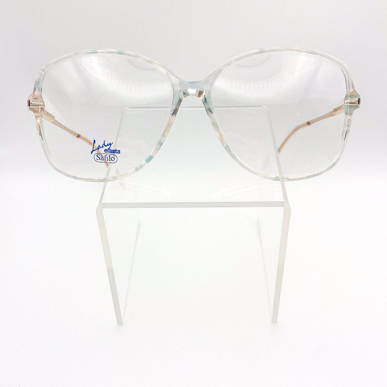 Clear 1980s eyeglasses with gold and peach frame on a white background
