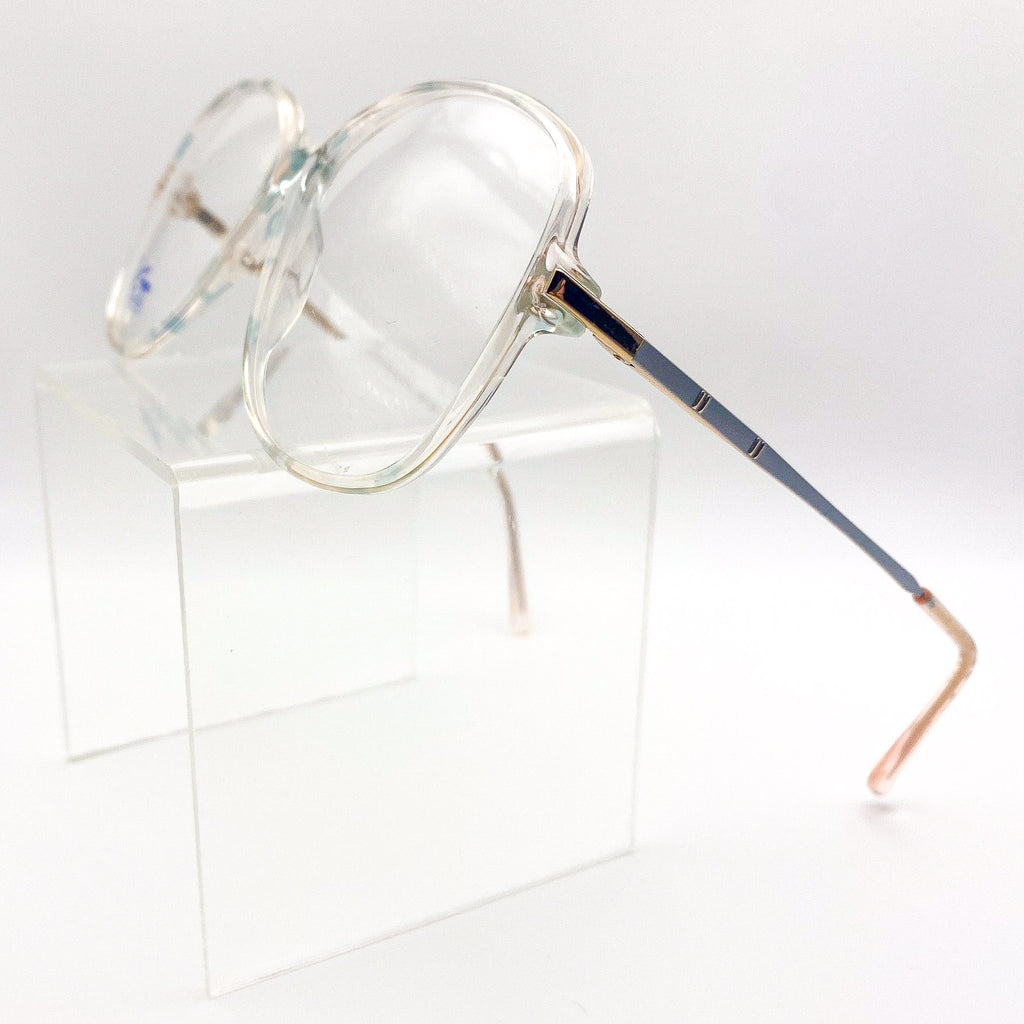 Clear eyeglasses with peach and green accents on a white background