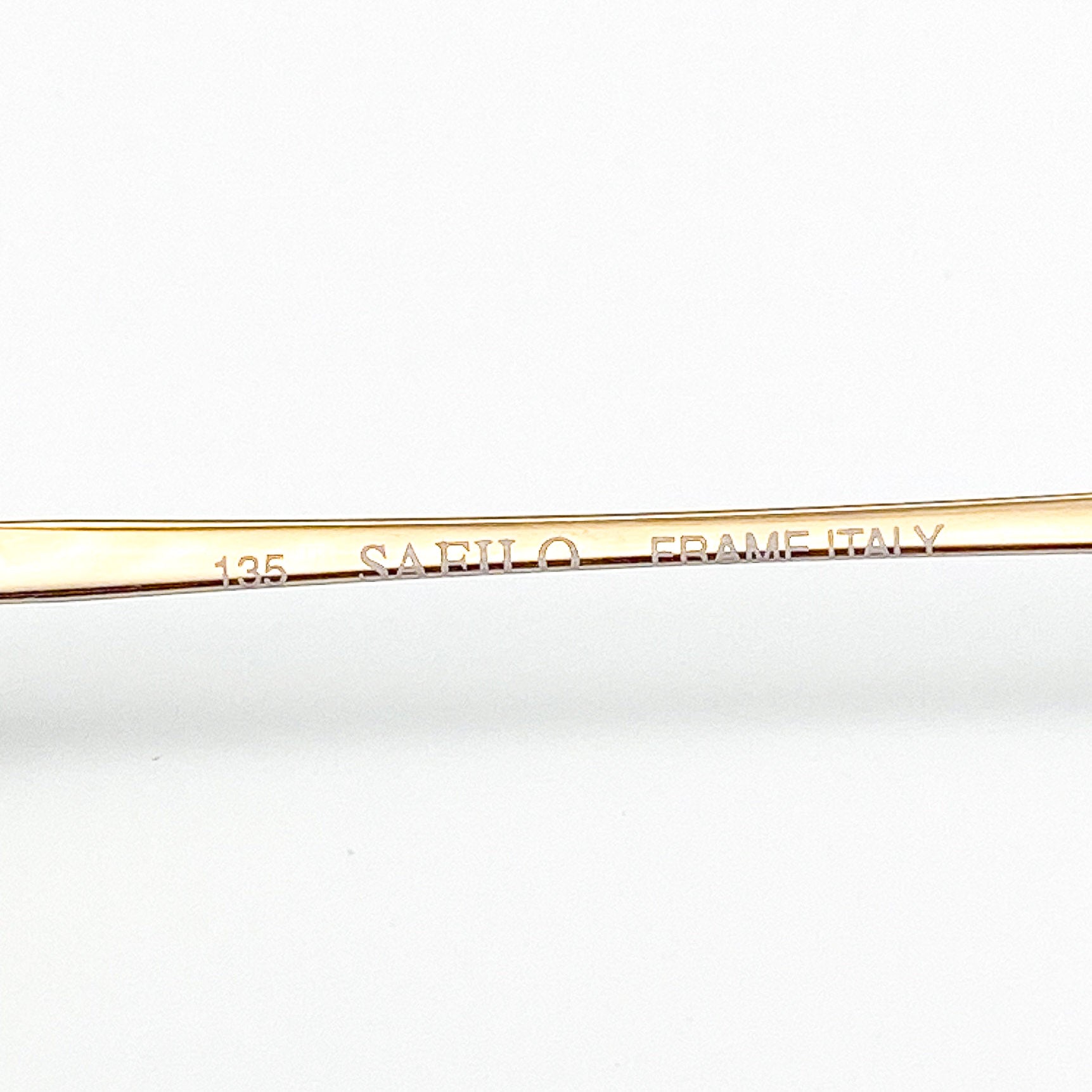 Gold frame with 'Safilo Frame Italy' engraving on a white background