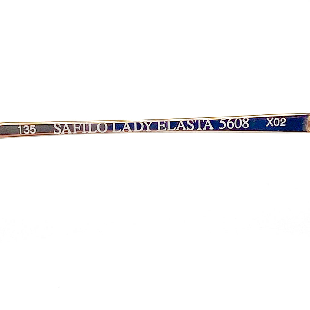 Gold eyeglasses with brand and model details on a white background