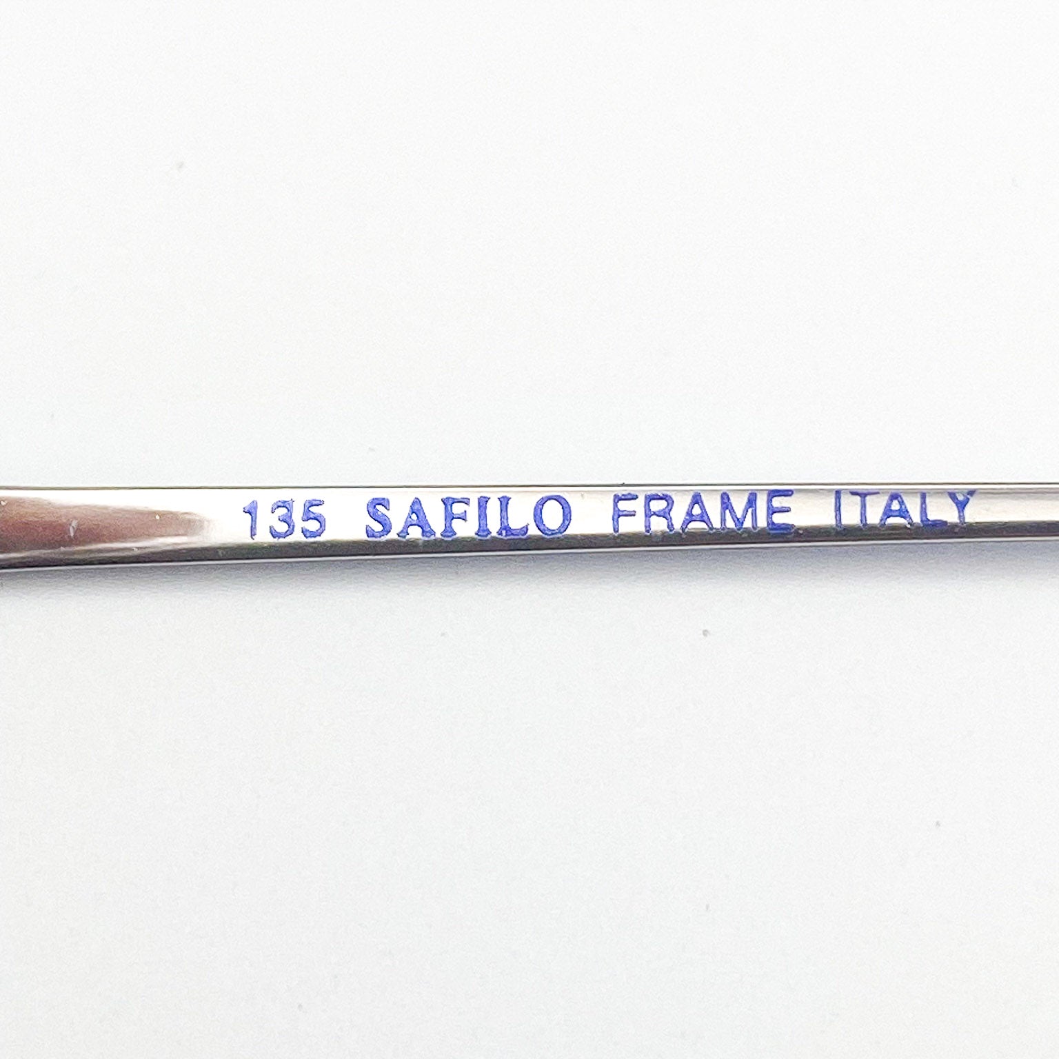 Metal frame with '135 SAFILO FRAME ITALY' engraving on a white background