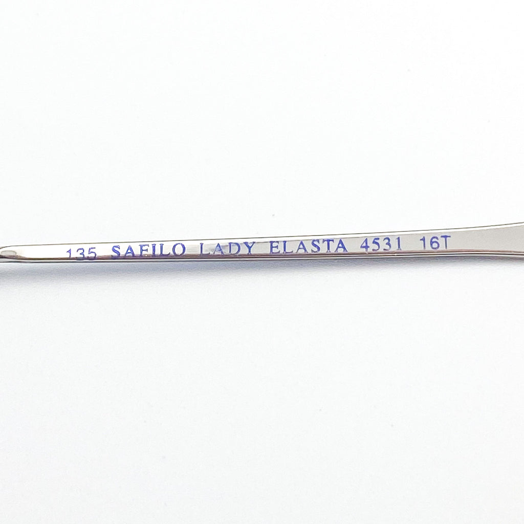 Metal eyeglass arm with 'Safilo Lady Elasta' branding on a white background