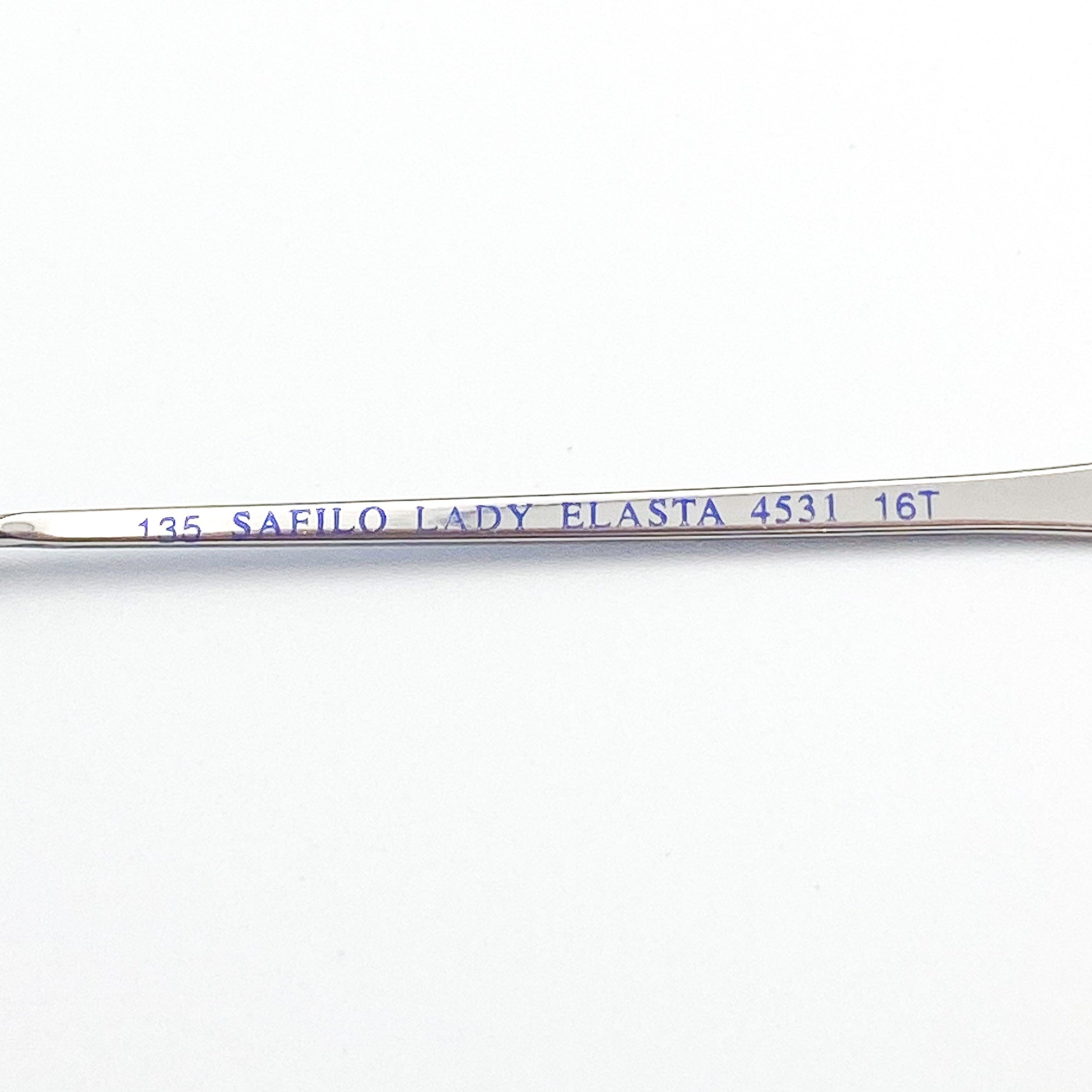 Metal eyeglass arm with 'Safilo Lady Elasta' branding on a white background