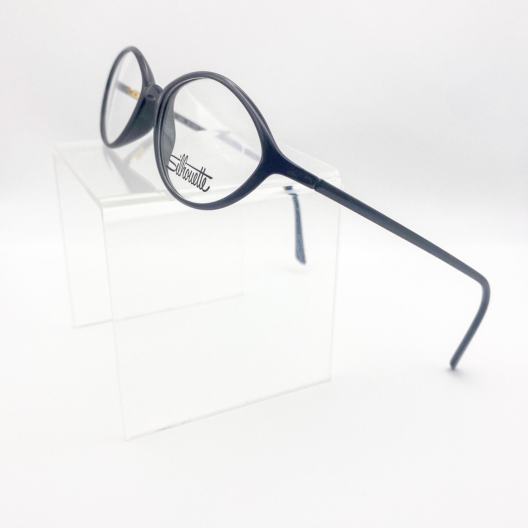 1980s black eyeglasses with a 'Silhouette' brand logo on a white background