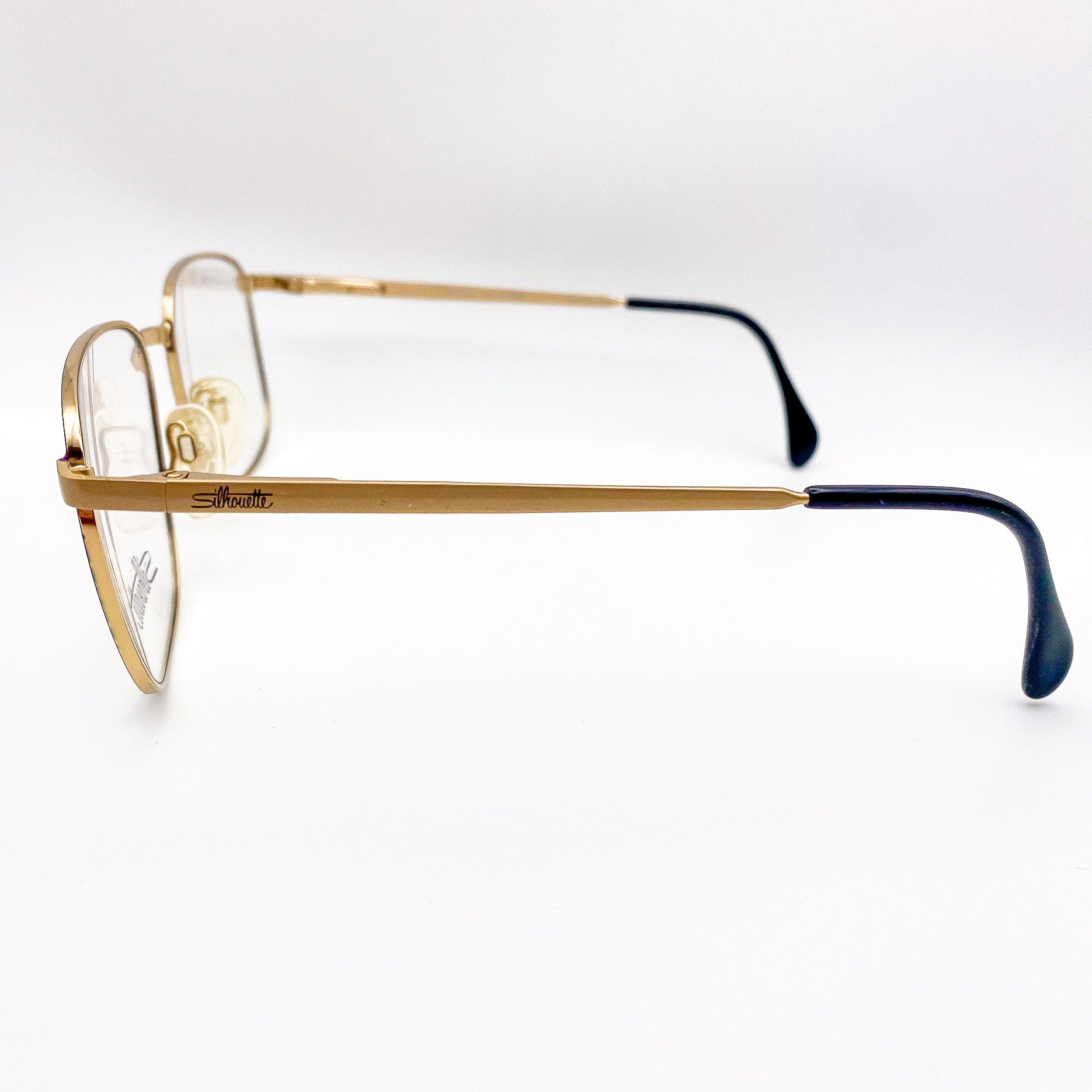 1990s gold metal frame eyeglasses on white background