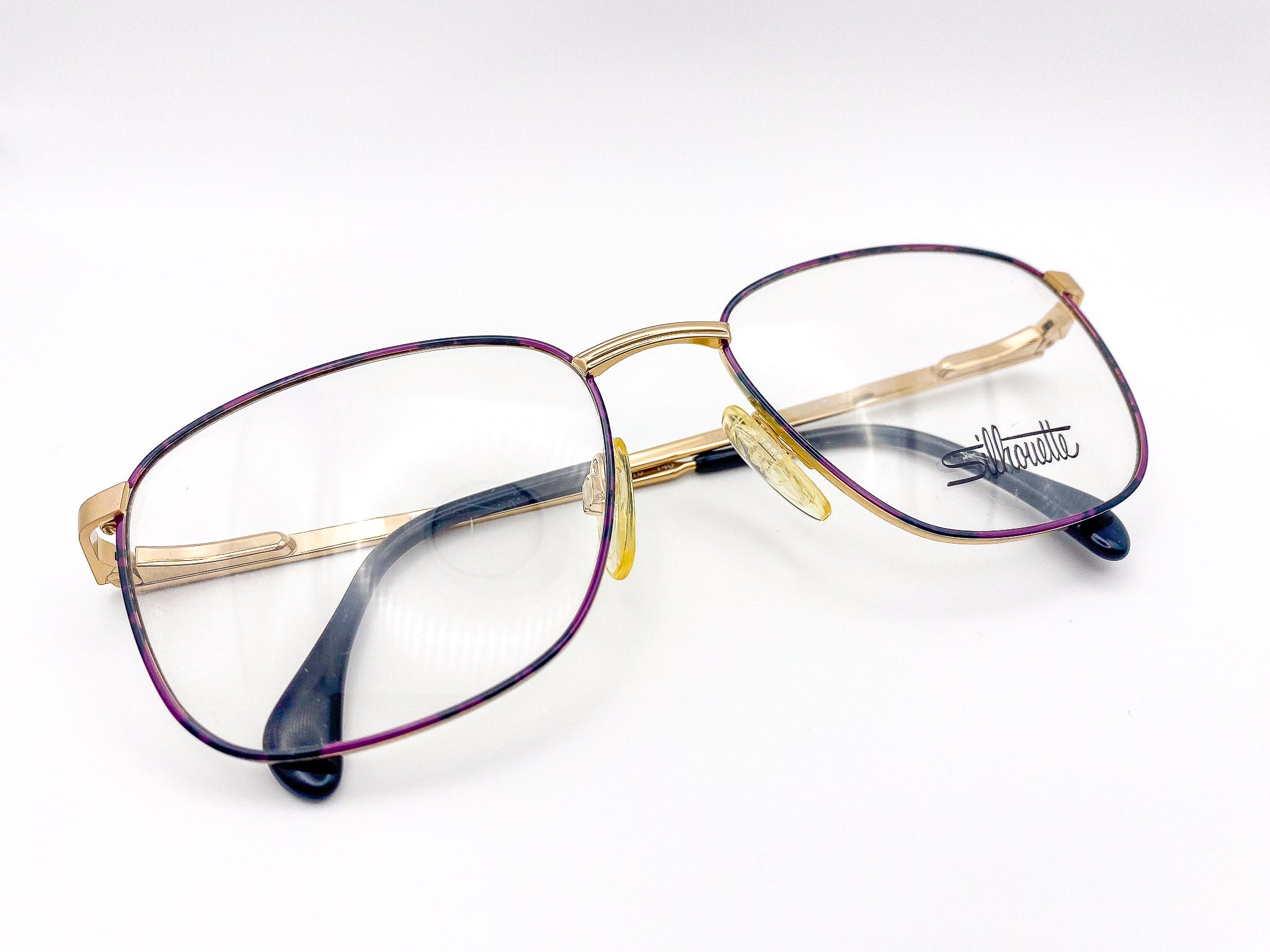 Vintage purple and black eyeglasses with gold frame and 'Silhouette' branding