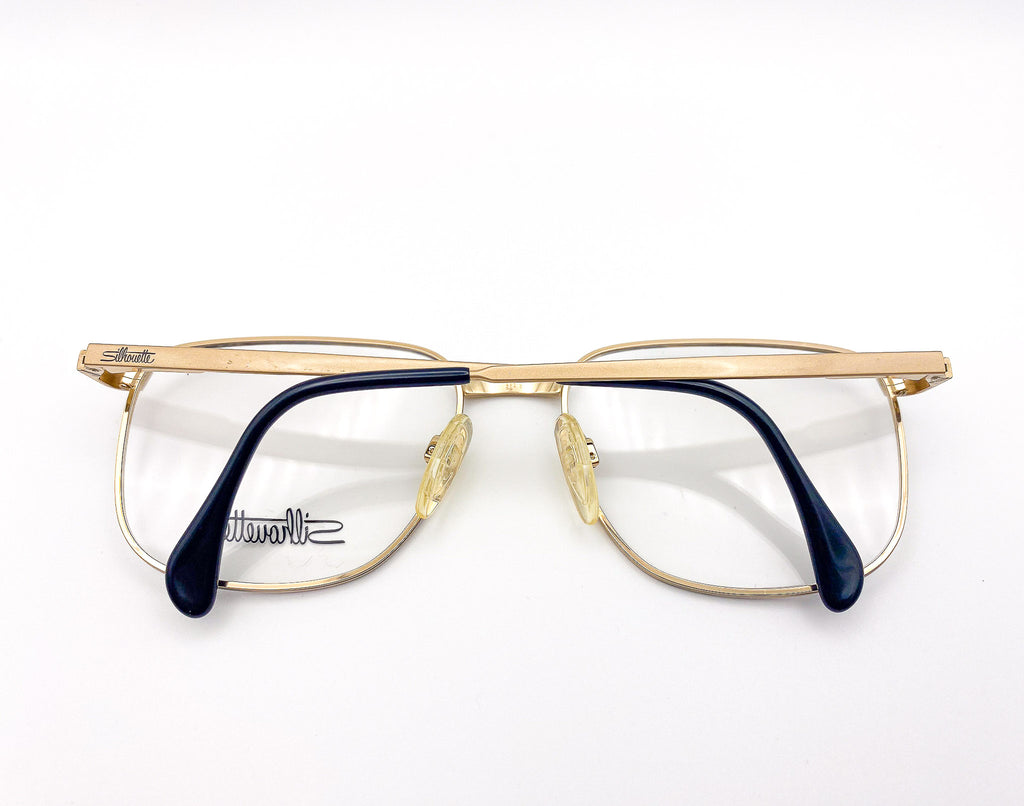 Vintage gold and black eyeglasses on a white background