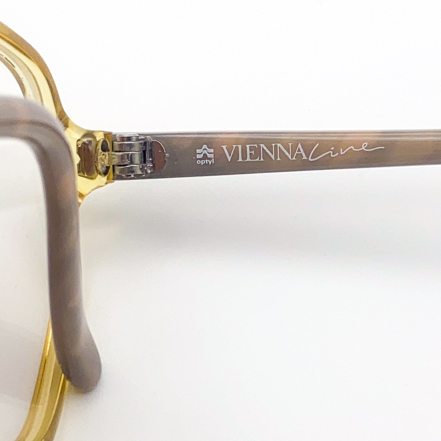 Close-up of a pair of eyeglasses with 'Vienna Line' branding on a white background