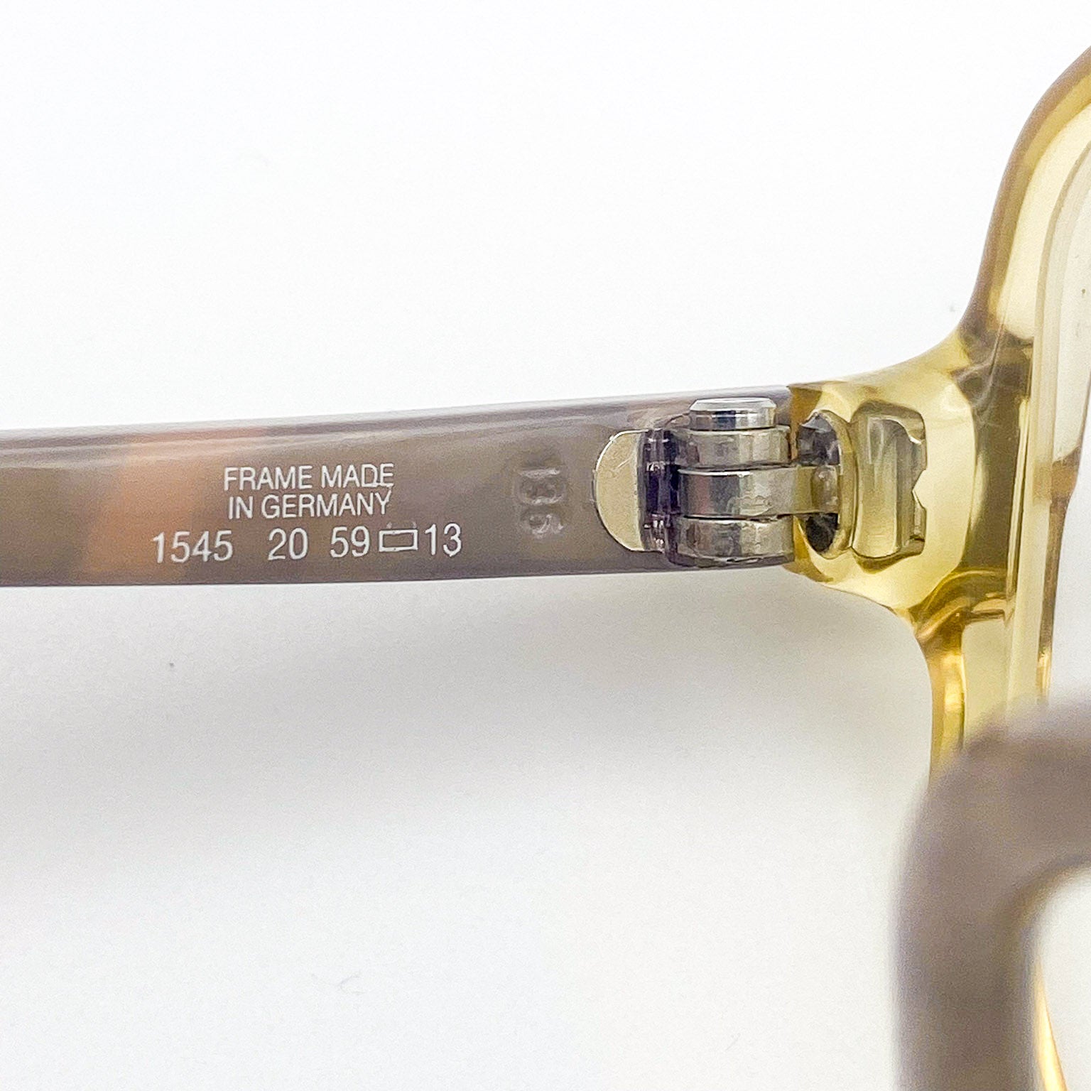 Close-up of eyeglass frame with 'Made in Germany' label on a white background