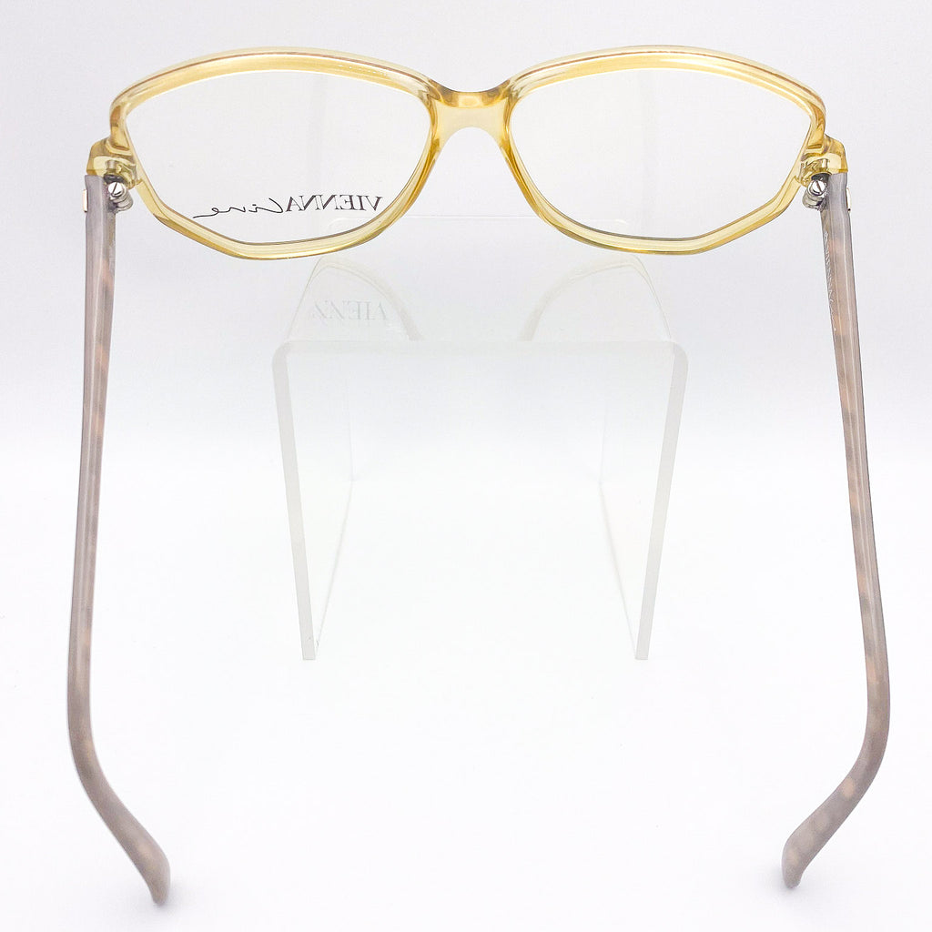 Eyeglasses with gold frame and gray temples on a white background