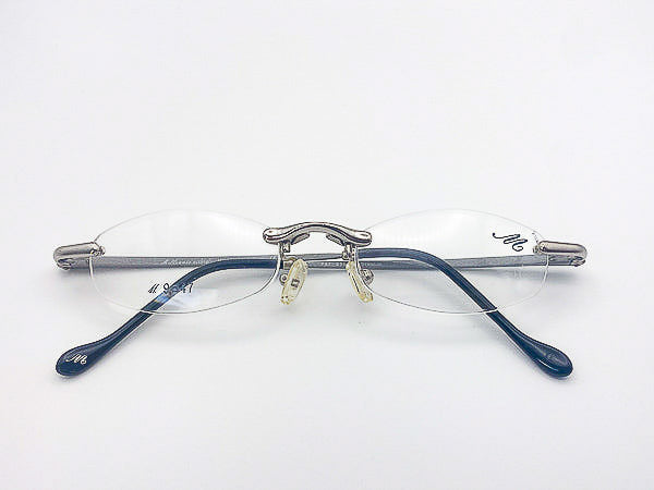 Vintage Millennio eyeglasses with silver rimless frame on a white background