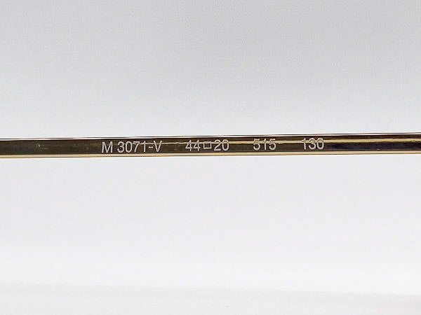 Metal temple rod with engraved text on a white background