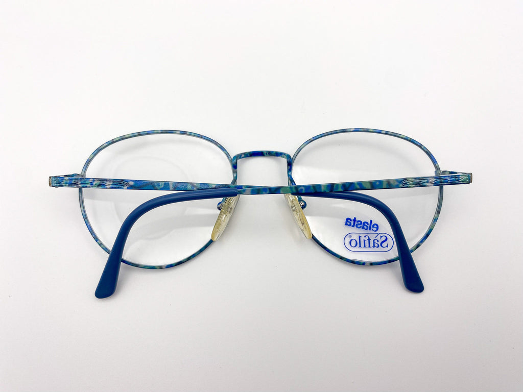 Pair of eyeglasses with teal metal rame and 'Safilo' logo on a white background