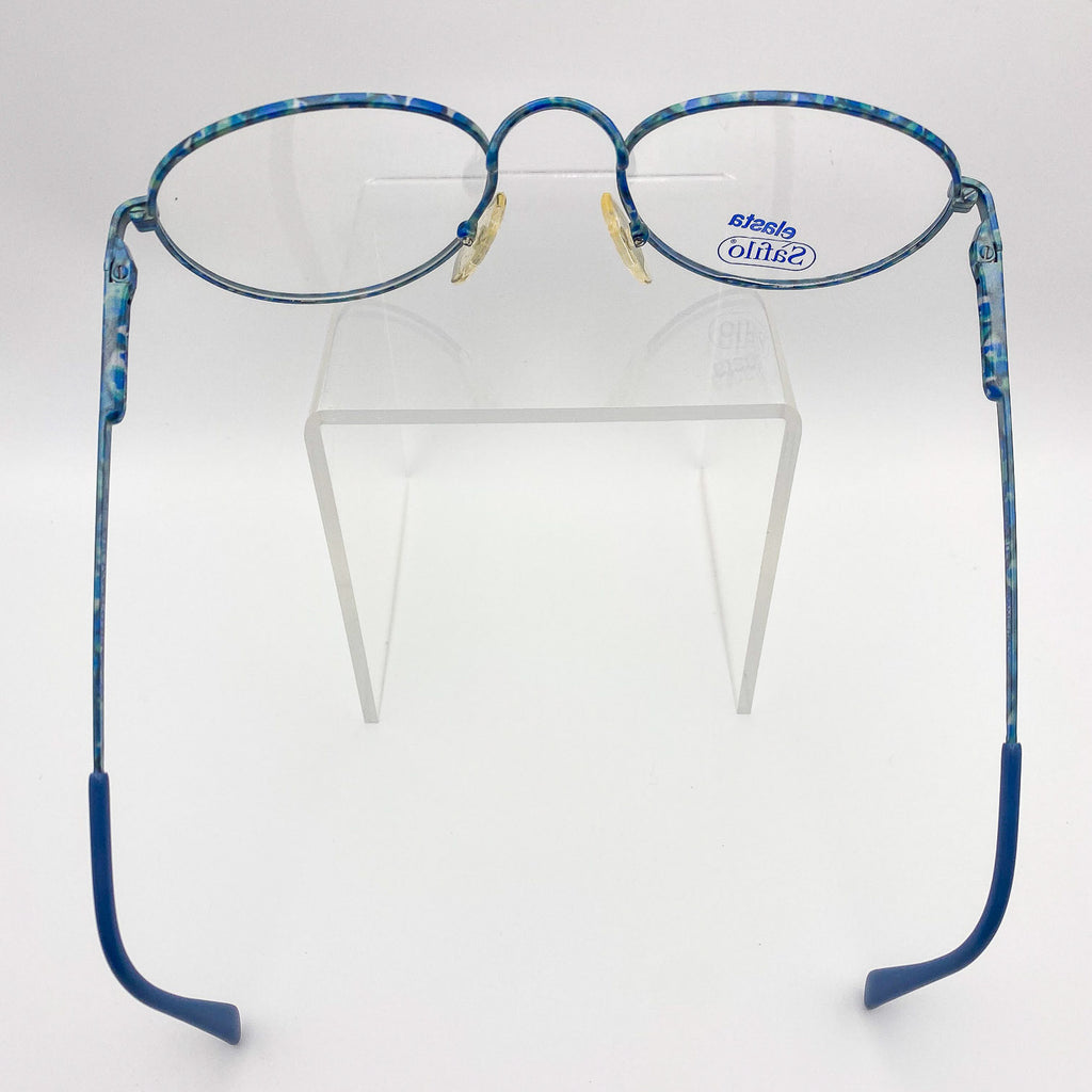 Blue eyeglasses on a clear stand against a white background