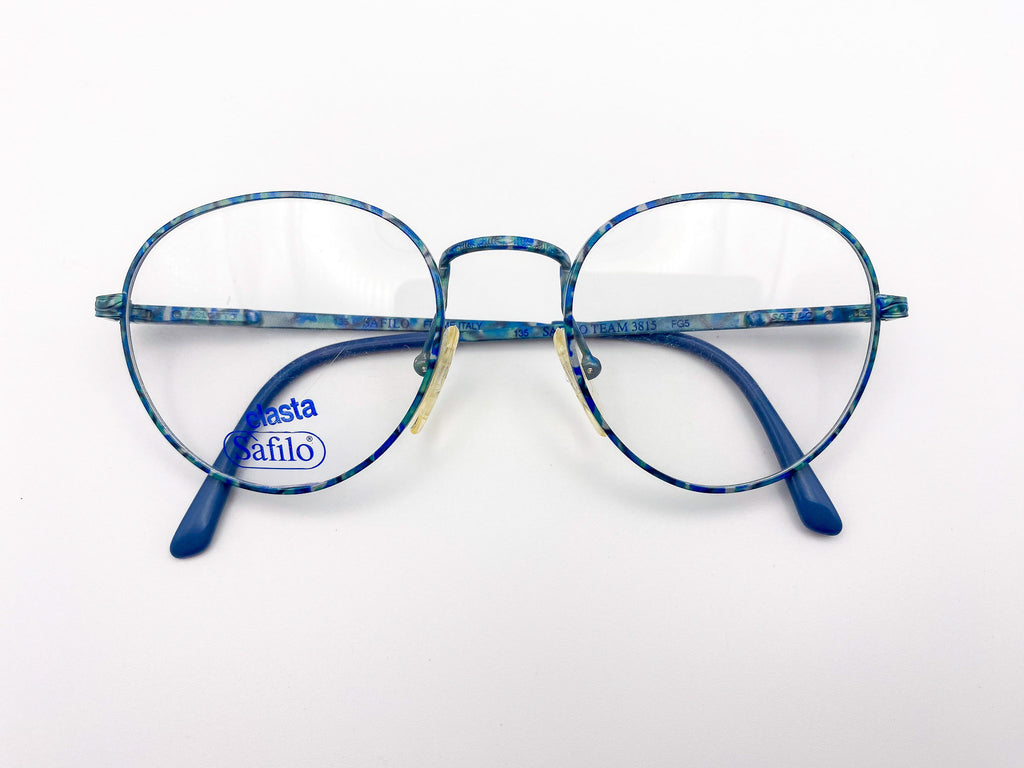 1980s teal metal eyeglasses with 'Safilo' branding on a white background