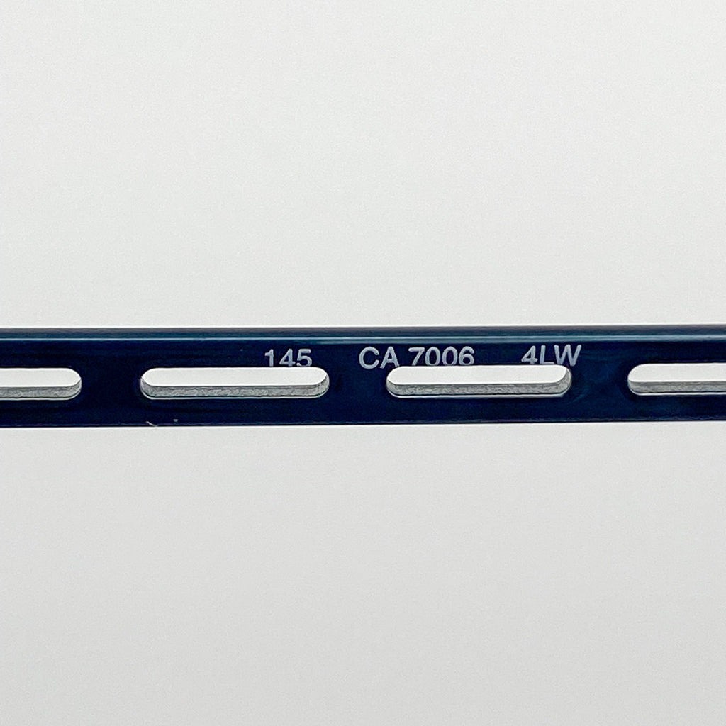 Close-up of a blue metal temple with engraved text on a white background