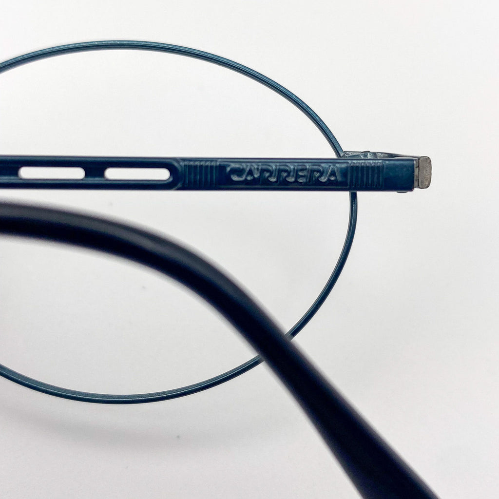 Close-up of a blue eyeglass frame with 'Carrera' branding on a white background