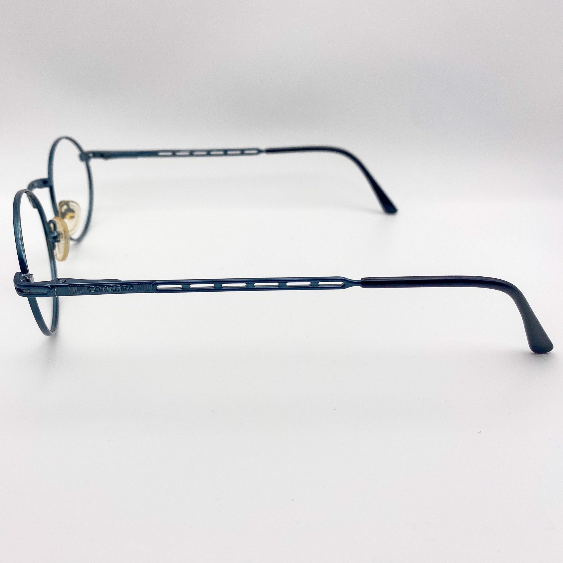 Teal blue eyeglasses on a light gray background