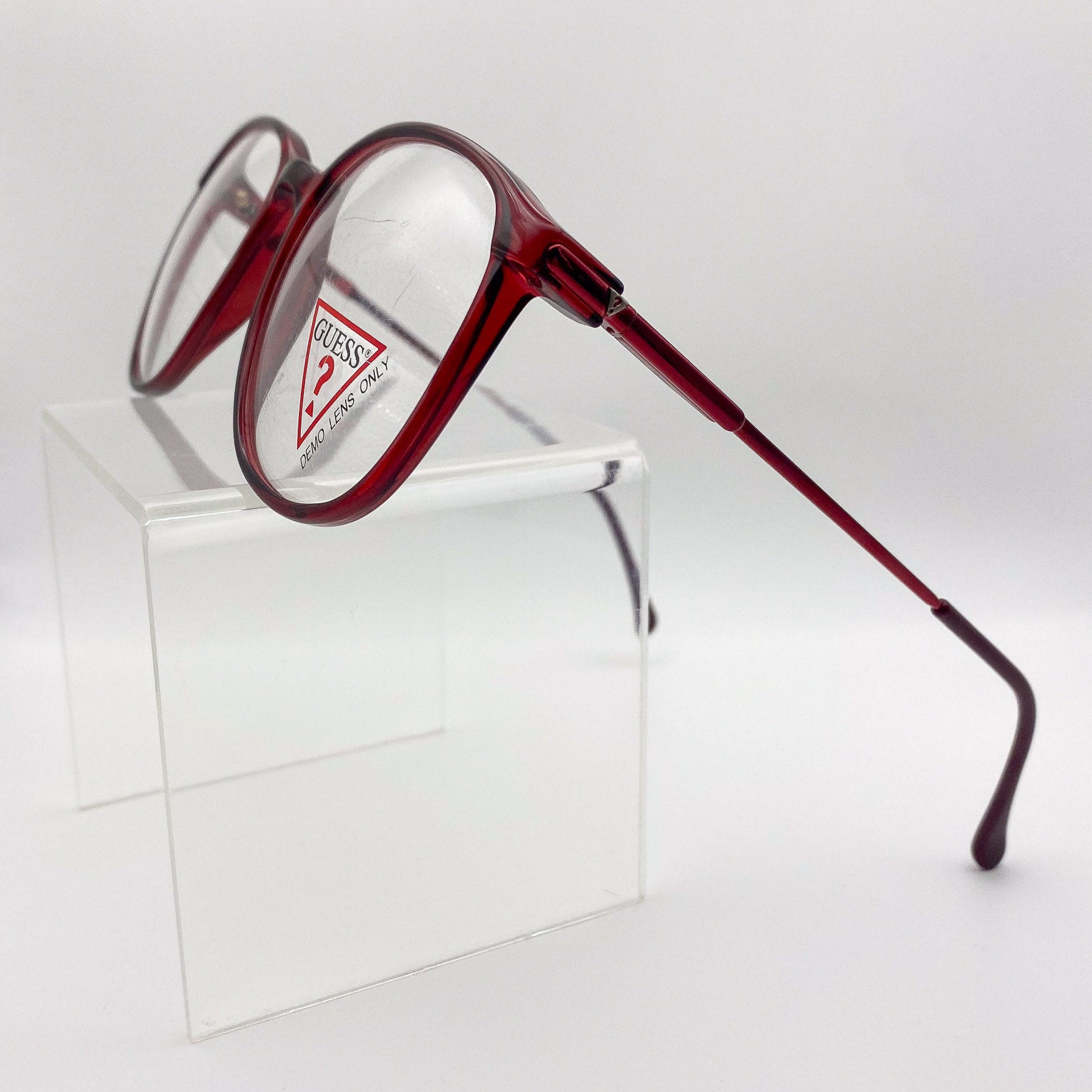 Red eyeglasses with Guess logo on a white background