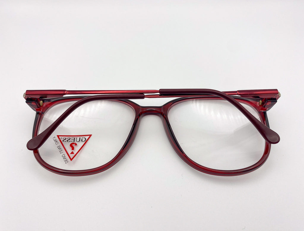 Oversized red eyeglasses with a visible brand logo on a white background