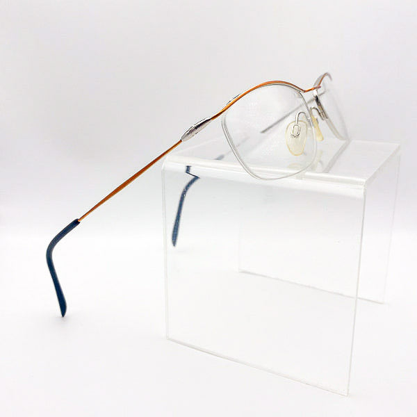 Eyeglasses with a multicolored frame on a clear stand against a white background