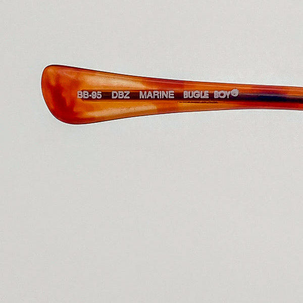 Tortoiseshell temple tip with text on a light gray background