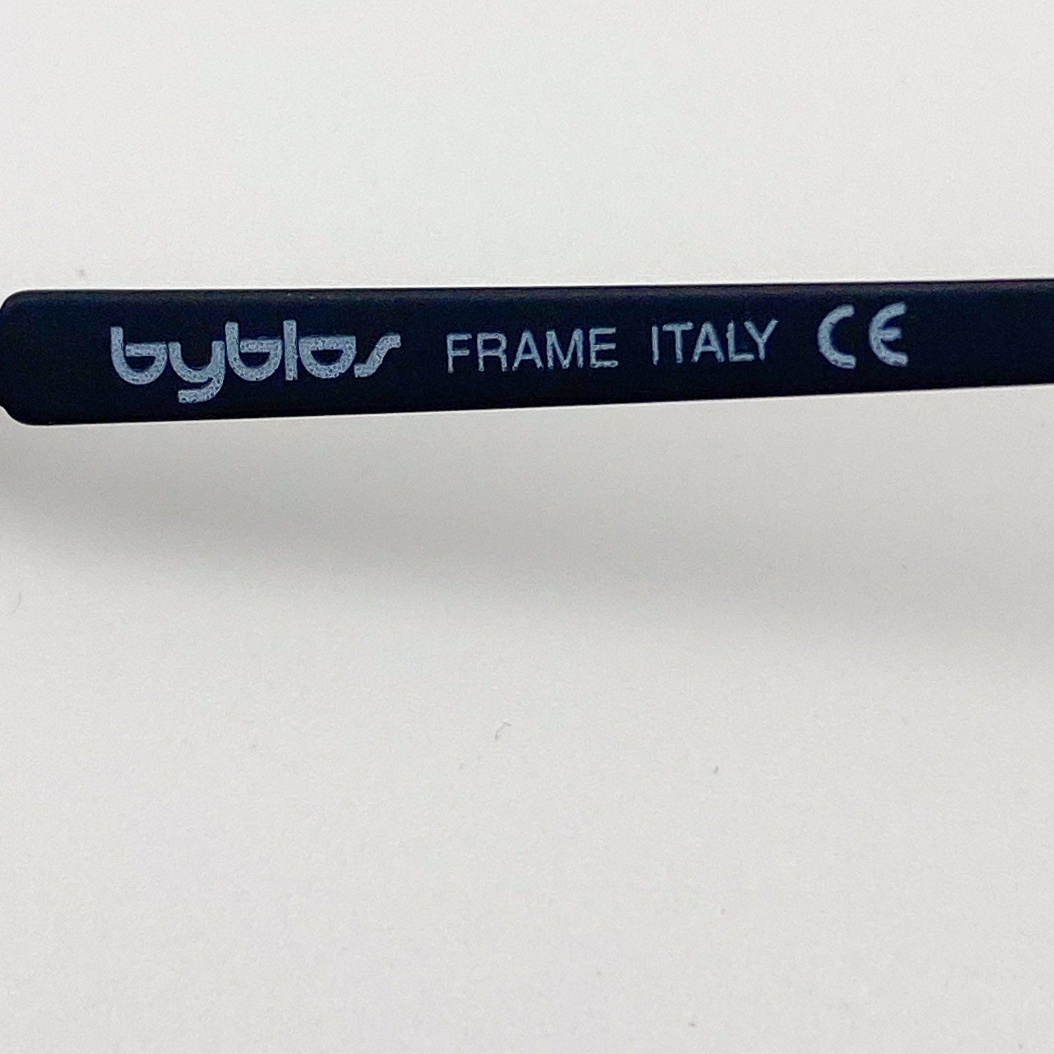 Eyeglass frame with 'byblos' branding and 'FRAME ITALY' text on a white background