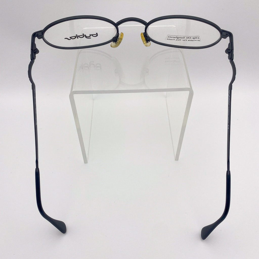 Black metal eyeglasses on a clear stand against a white background