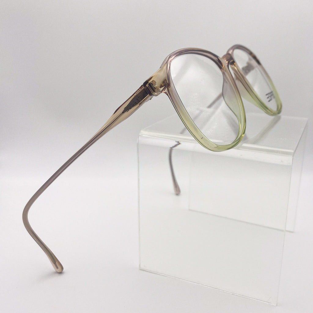 Brown and green eyeglasses with a gradient frame on a white surface
